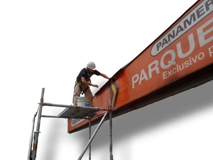A worker installing a Panamericana storefront sign